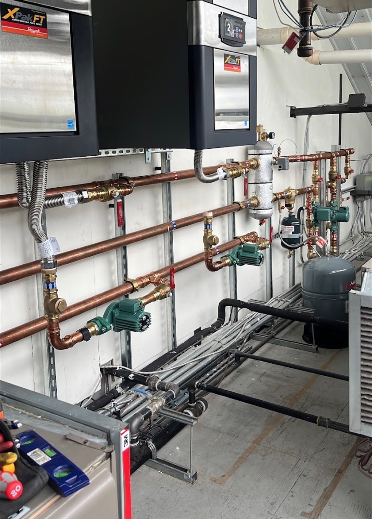 Commercial boiler installation with copper piping and circulation pumps