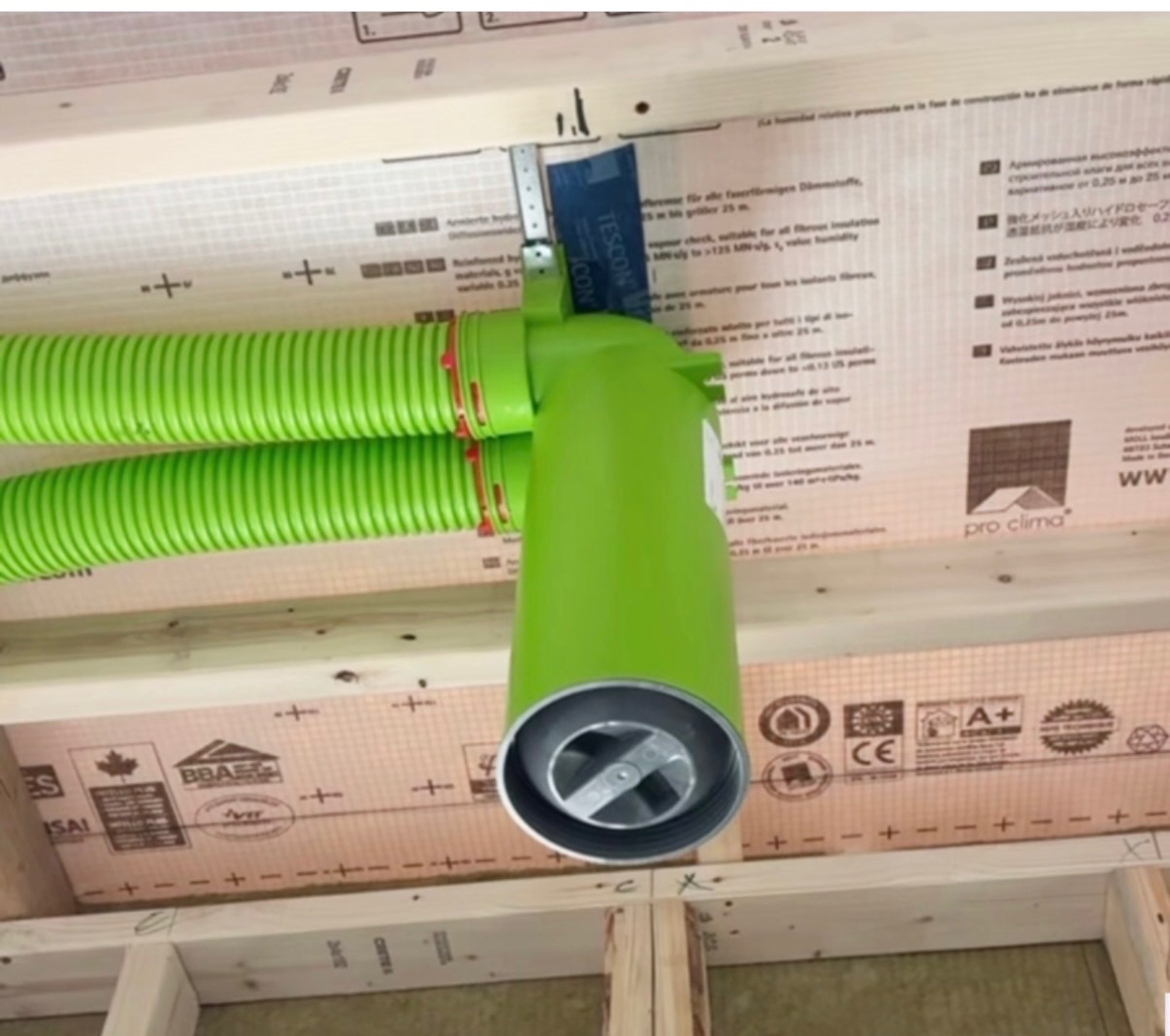 HRV ventilation ductwork with green Zehnder tubing and damper installed in new construction ceiling